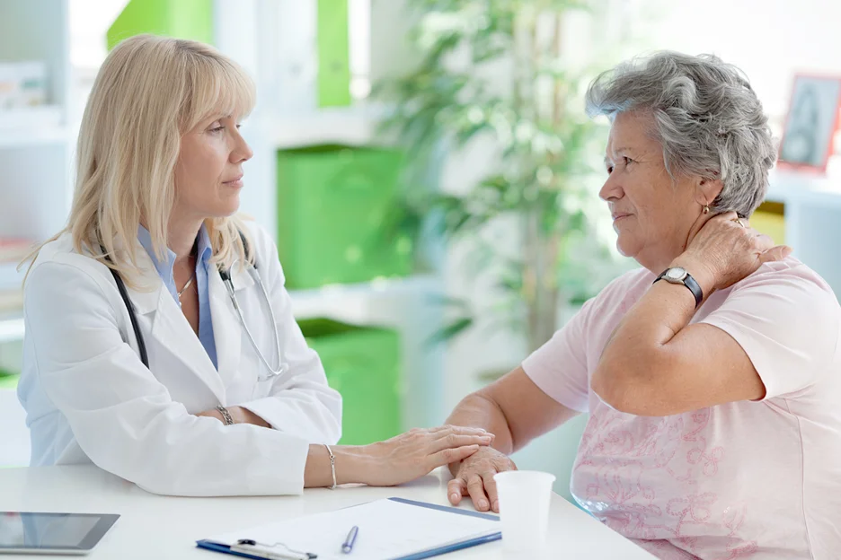 senior woman consults her doctor with regards to her neck pain